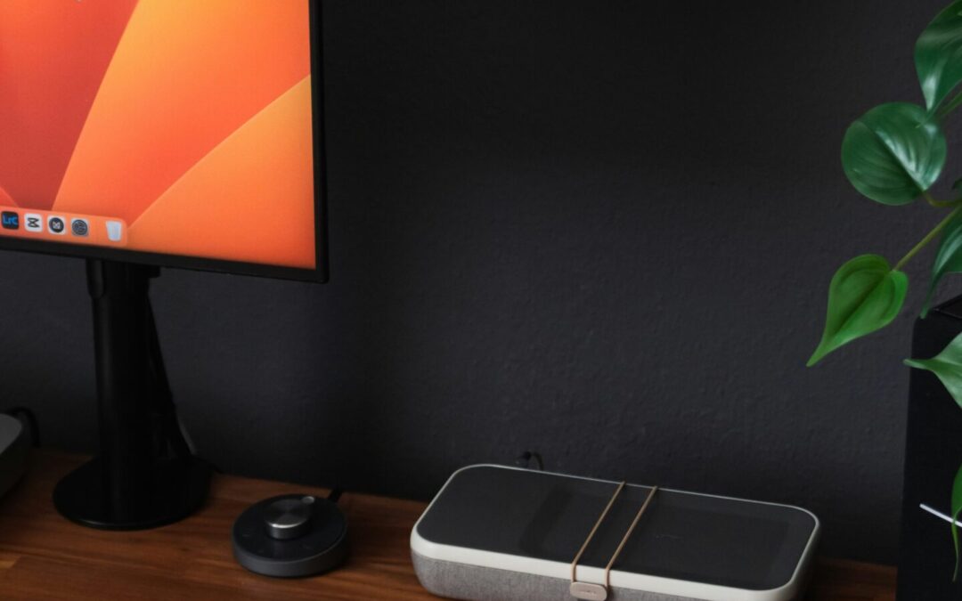 a desk with a laptop, keyboard, mouse and a monitor